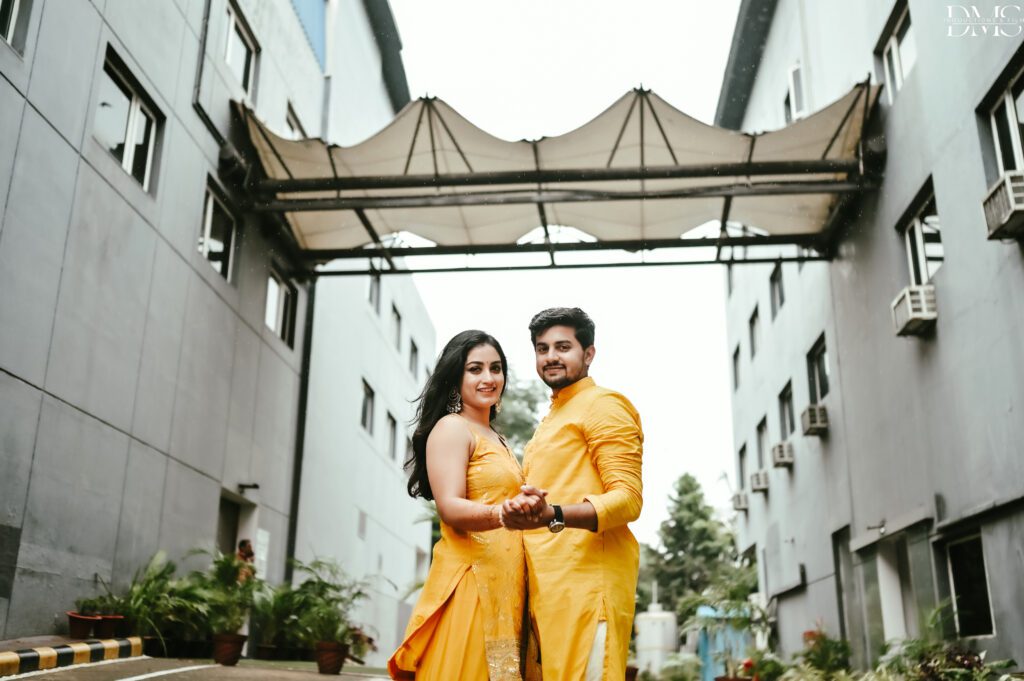 A Couple Dressed in yellow outfit posing themselves for wedding photographers