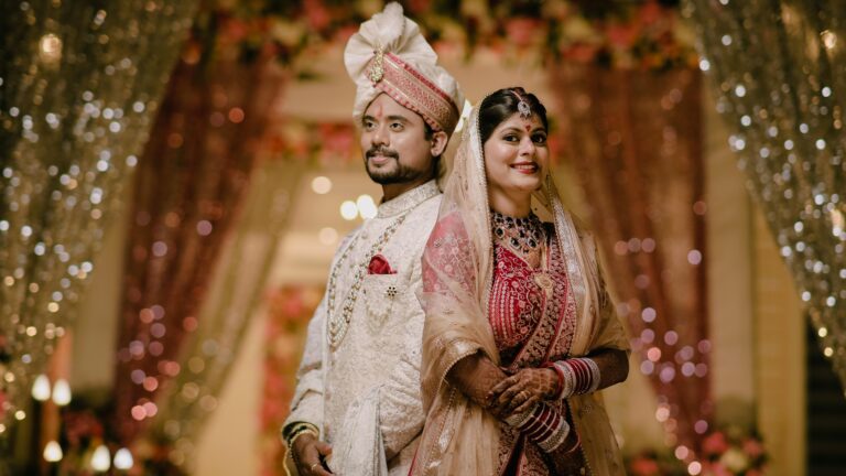 Traditional Indian bride and groom posing at their wedding reception under elegant floral and light decorations, photographed by DMS Productions and Films in Bhubaneswar.