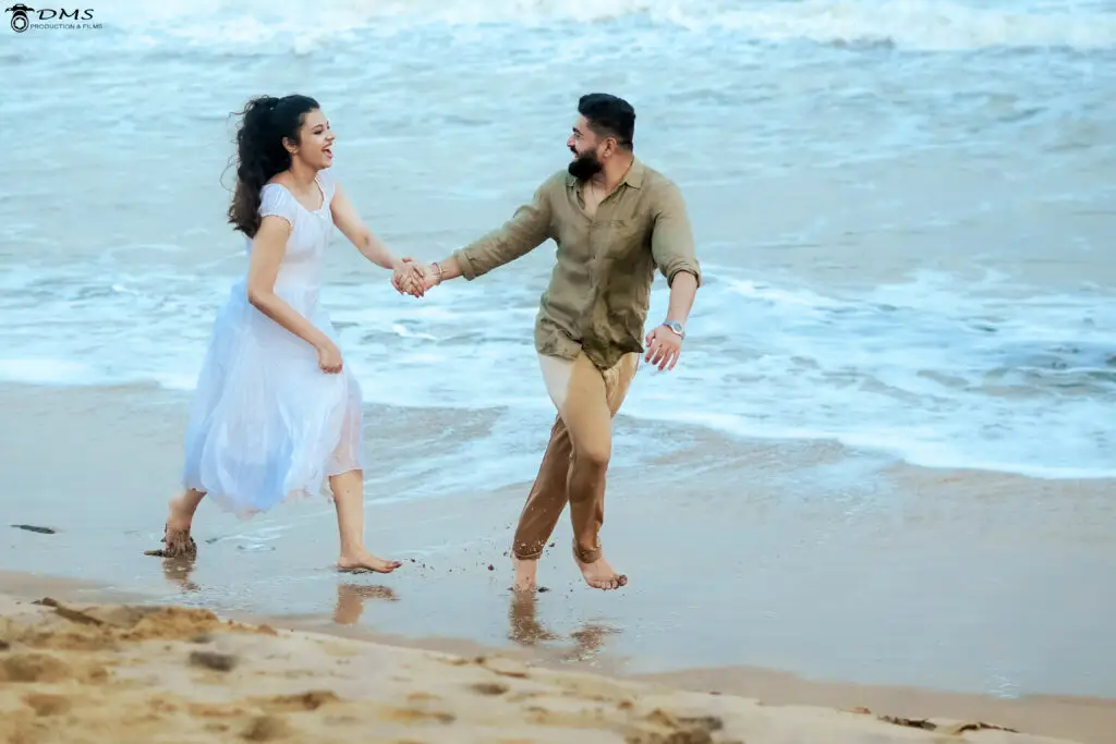 Pre wedding photogrpahy of couple running at the beach holding hands together