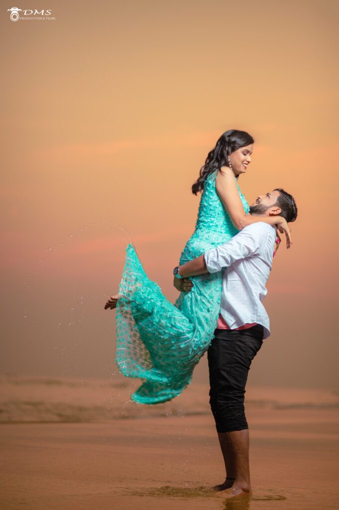 a prewedding photograph of couple at the puri beach where groom lifted the bride in air and looking at each other