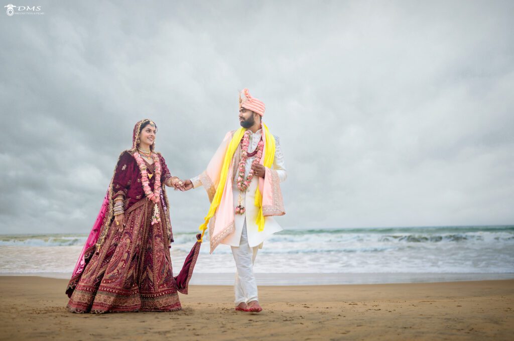 A wedding couple walking on the puri sea beach holding their hands together and looking at each other