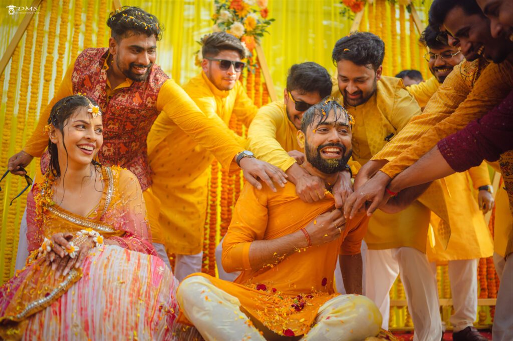 Haldi ceremony photogrpahy of bride and groom where their friends are doing fun with bride