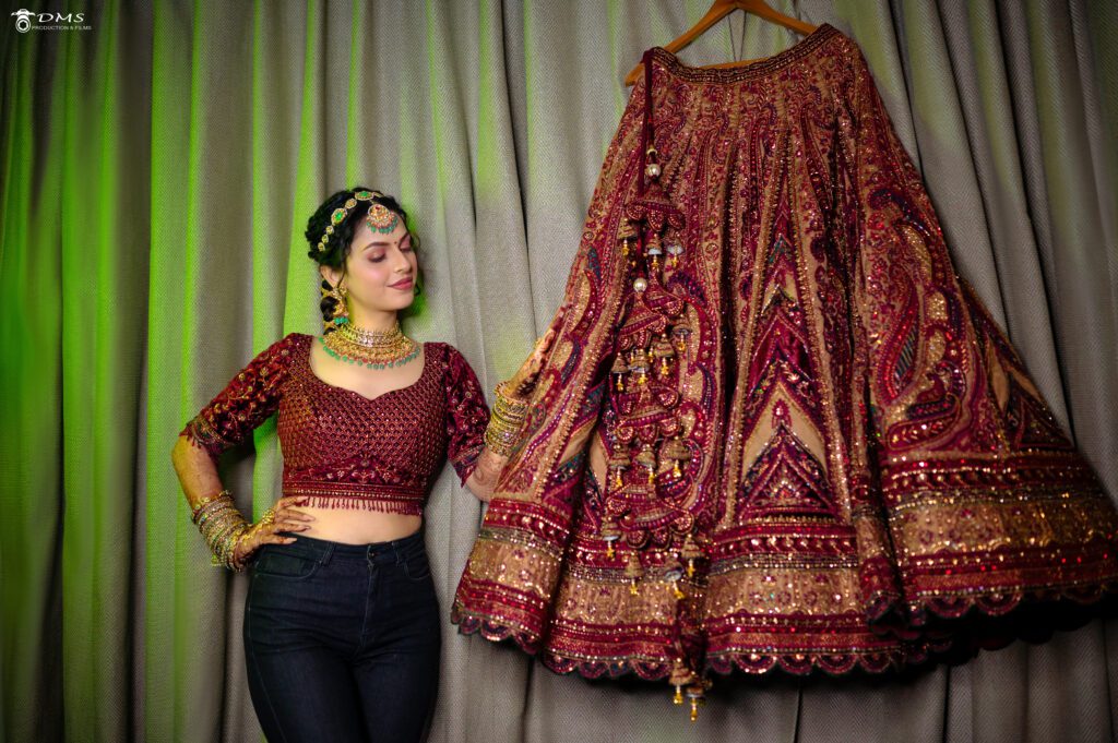 Lost in the moment, the bride lovingly touches her wedding lehenga, a symbol of her wedding day